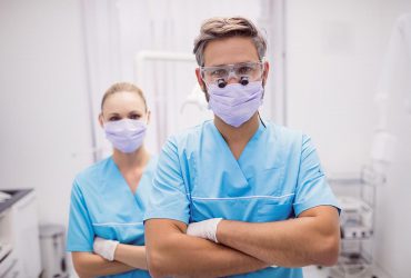 dentist standing with arms crossed dental clinic